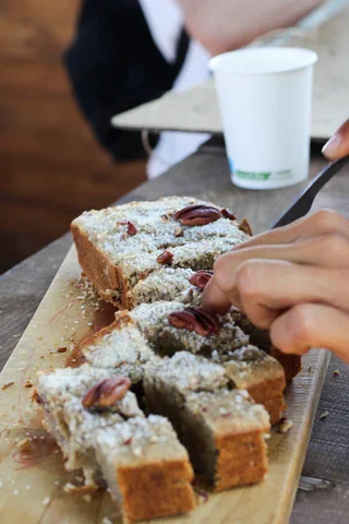 Dettaglio di un dolce al cocco affettato su un tagliere di legno