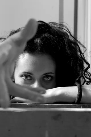 Autoritratto in bianco e nero: una mano incornicia lo sguardo