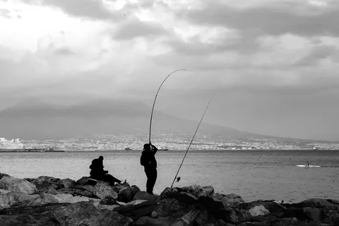 Pescatori sulla banchina con il Vesuvio sullo sfondo