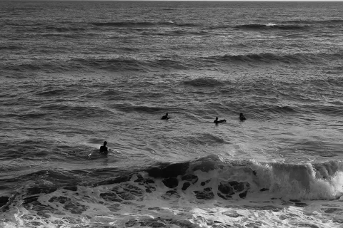 Surfisti seduti sulle tavole al largo, in attesa dell'onda